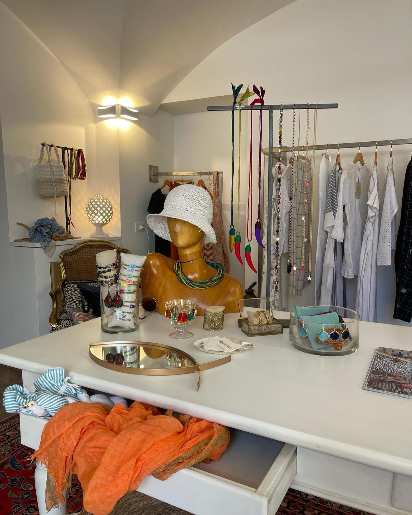 Vetrina d'ingresso del negozio Imperatrice a Spotorno in esposizione vestiti da donna di colore rosa e accessori come collane e bracciali